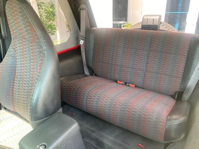 1999 Flame Red /Agate Jeep Wrangler Sport AUTO AC 4.0 6 CYL LOW MILES 92,727 (1J4FY19S2XP) with an 4.0L SMPI I6 Power Tech Engine engine, Automatic transmission, located at 4701 North Dixie Hwy, Pompano Beach, FL, 33064, (954) 422-2889, 26.240938, -80.123474 - OUR WEBPAGE FLORIDACARS1.COM HAS OVER 100 PHOTOS AND FREE CARFAX LINK 1999 Jeep Wrangler Sport 4WD Utility 4.0L I6 F Gasoline 20 MPG Rear Wheel Drive w/ 4X4 Features 4WD/AWD Air Conditioning Alloy Wheels AM/FM Stereo Automatic Transmission CD Audio Cloth Seats Cruise Control Running Boards Soft Top- Photo#71