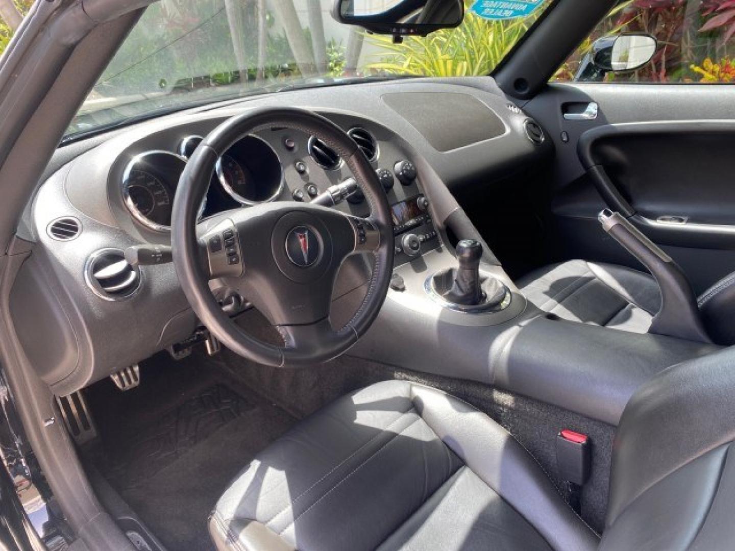 2008 Mysterious (Black) /Ebony Pontiac Solstice GXP 2.0 ECOTURBO LOW MILES 26,059 (1G2MG35X28Y) with an Turbo Ecotec 2.0L VVT DOHC 4-Cyl Aluminum Engine engine, Manual transmission, located at 4701 North Dixie Hwy, Pompano Beach, FL, 33064, (954) 422-2889, 26.240938, -80.123474 - OUR WEBPAGE FLORIDACARS1.COM HAS OVER 100 PHOTOS AND FREE CARFAX LINK 2008 Pontiac Solstice GXP Convertible 2.0L I4 F Gasoline 31 MPG Rear Wheel Drive Features ABS Brakes Air Conditioning Alloy Wheels AM/FM Stereo Auxiliary Audio Input CD Audio Convenience Package Cruise Control Leather Seats Manual- Photo#48
