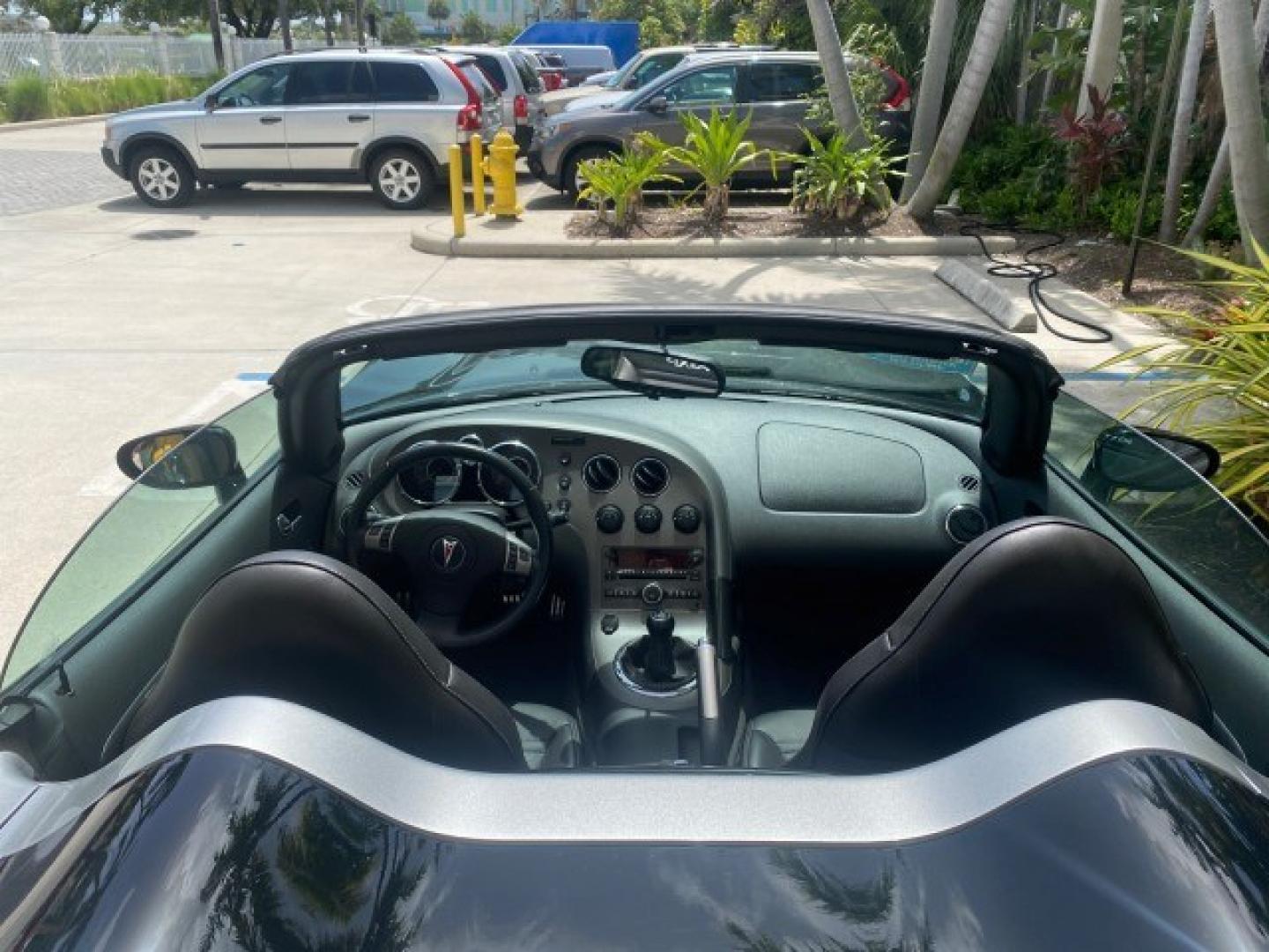 2008 Mysterious (Black) /Ebony Pontiac Solstice GXP 2.0 ECOTURBO LOW MILES 26,059 (1G2MG35X28Y) with an Turbo Ecotec 2.0L VVT DOHC 4-Cyl Aluminum Engine engine, Manual transmission, located at 4701 North Dixie Hwy, Pompano Beach, FL, 33064, (954) 422-2889, 26.240938, -80.123474 - OUR WEBPAGE FLORIDACARS1.COM HAS OVER 100 PHOTOS AND FREE CARFAX LINK 2008 Pontiac Solstice GXP Convertible 2.0L I4 F Gasoline 31 MPG Rear Wheel Drive Features ABS Brakes Air Conditioning Alloy Wheels AM/FM Stereo Auxiliary Audio Input CD Audio Convenience Package Cruise Control Leather Seats Manual- Photo#94