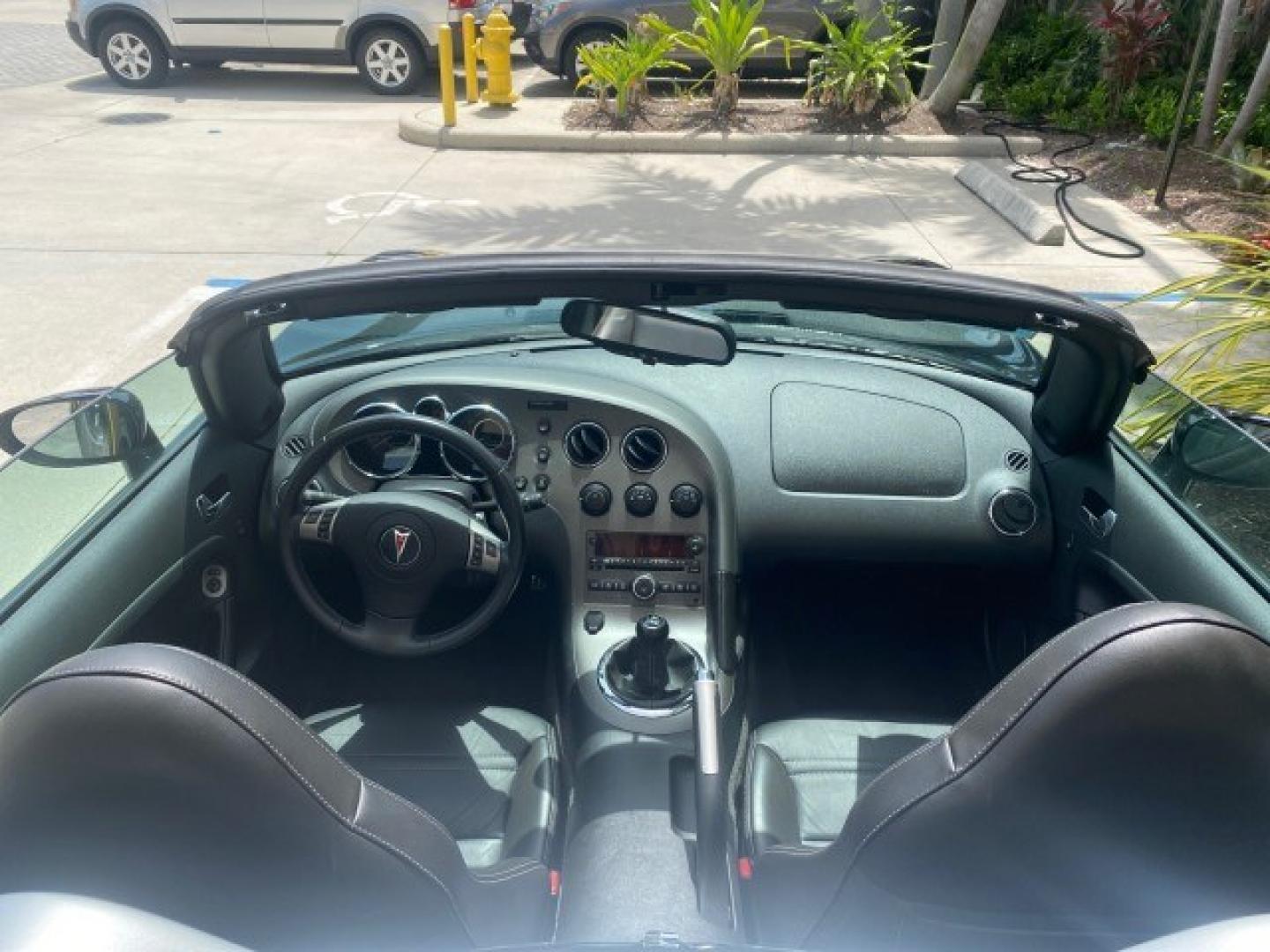 2008 Mysterious (Black) /Ebony Pontiac Solstice GXP 2.0 ECOTURBO LOW MILES 26,059 (1G2MG35X28Y) with an Turbo Ecotec 2.0L VVT DOHC 4-Cyl Aluminum Engine engine, Manual transmission, located at 4701 North Dixie Hwy, Pompano Beach, FL, 33064, (954) 422-2889, 26.240938, -80.123474 - OUR WEBPAGE FLORIDACARS1.COM HAS OVER 100 PHOTOS AND FREE CARFAX LINK 2008 Pontiac Solstice GXP Convertible 2.0L I4 F Gasoline 31 MPG Rear Wheel Drive Features ABS Brakes Air Conditioning Alloy Wheels AM/FM Stereo Auxiliary Audio Input CD Audio Convenience Package Cruise Control Leather Seats Manual- Photo#95