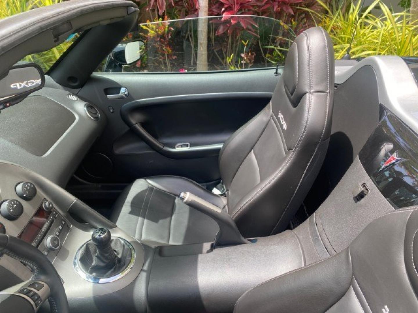 2008 Mysterious (Black) /Ebony Pontiac Solstice GXP 2.0 ECOTURBO LOW MILES 26,059 (1G2MG35X28Y) with an Turbo Ecotec 2.0L VVT DOHC 4-Cyl Aluminum Engine engine, Manual transmission, located at 4701 North Dixie Hwy, Pompano Beach, FL, 33064, (954) 422-2889, 26.240938, -80.123474 - OUR WEBPAGE FLORIDACARS1.COM HAS OVER 100 PHOTOS AND FREE CARFAX LINK 2008 Pontiac Solstice GXP Convertible 2.0L I4 F Gasoline 31 MPG Rear Wheel Drive Features ABS Brakes Air Conditioning Alloy Wheels AM/FM Stereo Auxiliary Audio Input CD Audio Convenience Package Cruise Control Leather Seats Manual- Photo#99